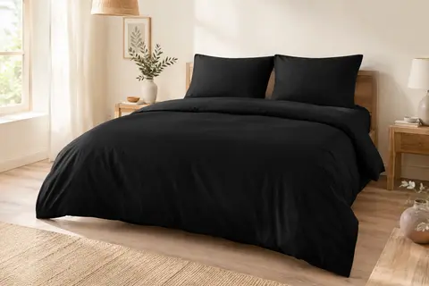 Parure de lit noire unie en microfibre avec housse de couette et deux taies assorties sur un lit