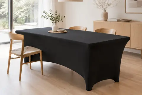 Nappe extensible noire ajustée sur une table rectangulaire en bois clair, avec poches autour des pieds.